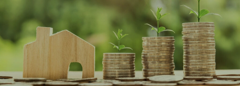 Stacks of quarters with little plants growing from them next to a playwood house cutout offering rebates and finance options