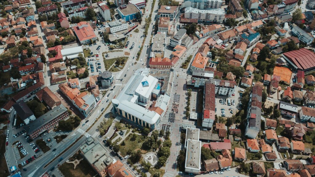 Aerial view of a city with densely packed buildings, roads, parked cars, and a central white building with columns and a blue roof—home to a leading HVAC Company Arlington trusts for comfort year-round.