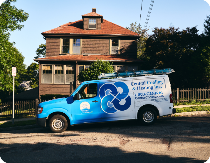 A white Central Cooling & Heating Inc. van is parked on a residential street in front of a brown house with a red roof.