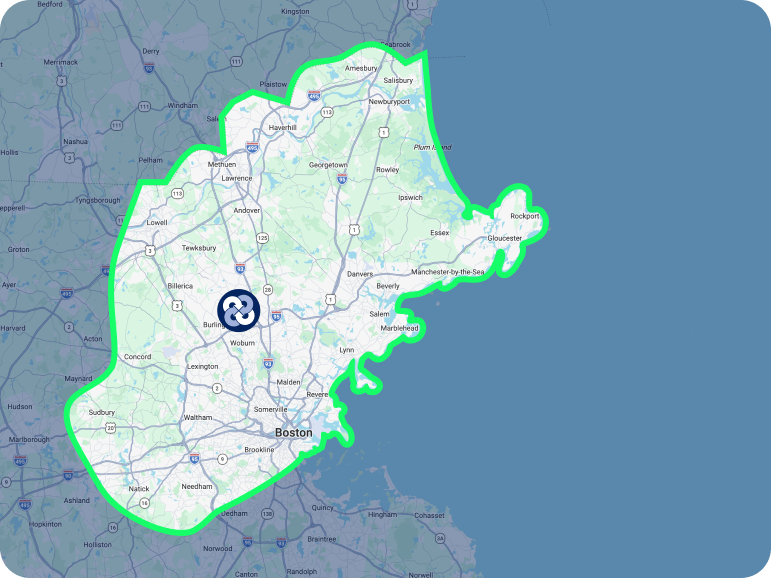 A map highlighting an area north of Boston, Massachusetts, with a bold green border and a dark circular icon near the center.