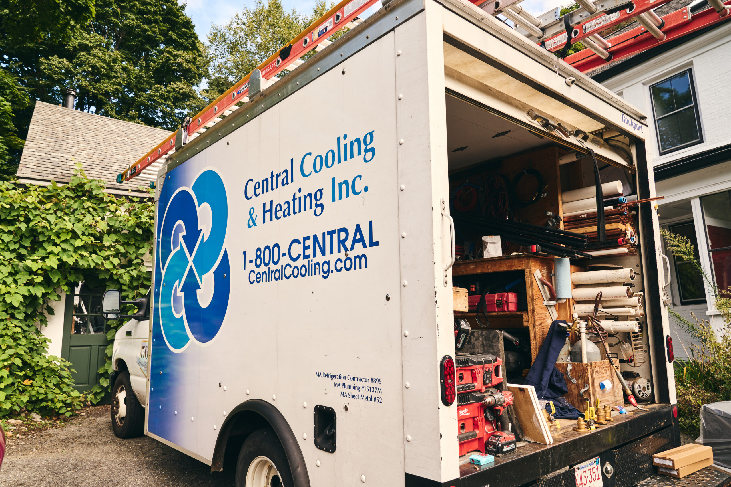 Central Cooling & Heating service truck stocked with HVAC tools and equipment parked outside a residential home